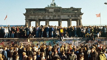 Menschenmassen stehen am 10.11.1989 vor und auf der Berliner Mauer am Brandenburger Tor. | Bild: picture-alliance/ dpa | dpa